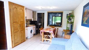 Un espacio habitable compacto con cocina, comedor y sofá.