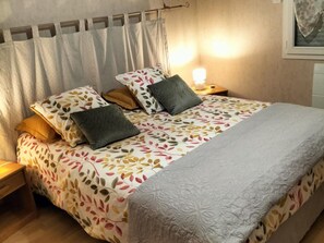 A neatly made bed with a patterned bedspread, pillows, and a blanket. There is a bedside lamp on the nightstand beside the bed. - Charming Family-Friendly Cottage, Pet Welcome, Garden, Near Blois & Loire Castles (Valencisse-Chambon-sur-Cisse)