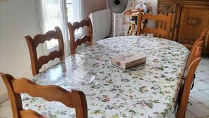 A dining table with a floral tablecloth, surrounded by wooden chairs. - Charming Family-Friendly Cottage, Pet Welcome, Garden, Near Blois & Loire Castles (Valencisse-Chambon-sur-Cisse)