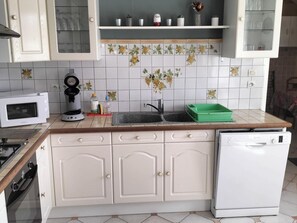 A kitchen with white cabinets, a microwave, a coffee maker, and a dishwasher. - Charming Family-Friendly Cottage, Pet Welcome, Garden, Near Blois & Loire Castles (Valencisse-Chambon-sur-Cisse)