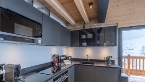 A modern kitchen with a built-in oven, a coffee machine, and a sink. - 125m² Ski-In Duplex with PARKING, 4 Bedrooms (Huez)