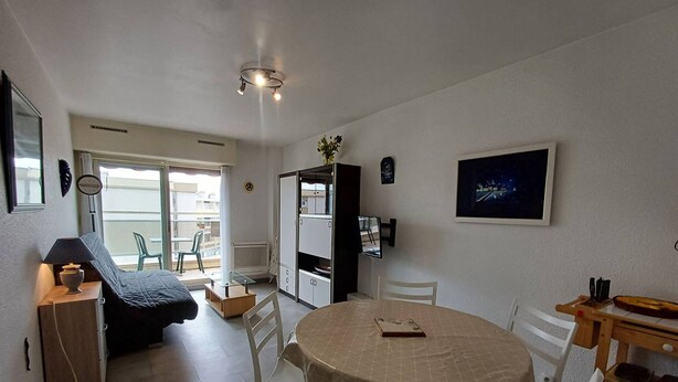 Ein kompakter Wohnbereich mit Essbereich, Küchenzeile und kleinem Balkon.