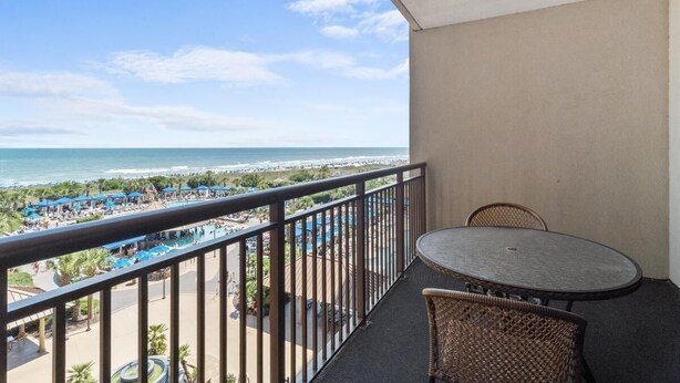 Un balcon avec vue sur la plage et sur l’espace piscine.