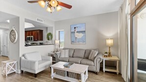 A living room with a sofa, armchair, coffee table, and a ceiling fan. - Spectacular 8th Floor Serenity: Oceanfront Views (North Myrtle Beach)