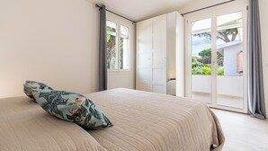 A bedroom with a bed, a window, and a sliding door leading to a balcony. - Villa Beachfront Marina (Santa Margherita di Pula)