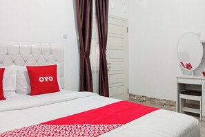 A hotel room with a white bed, red and white bedding, a mirror, and a white wardrobe. - Hotel O Homestay Jaya Putri 1 Syariah (Bandar Lampung)