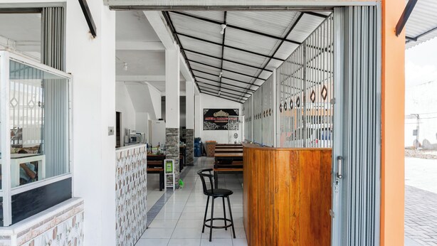 Un interno moderno con una reception, un'area salotto e un pavimento piastrellato.