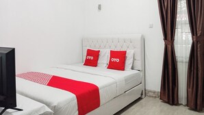 Una camera d'albergo con un letto, una televisione e delle tende.
