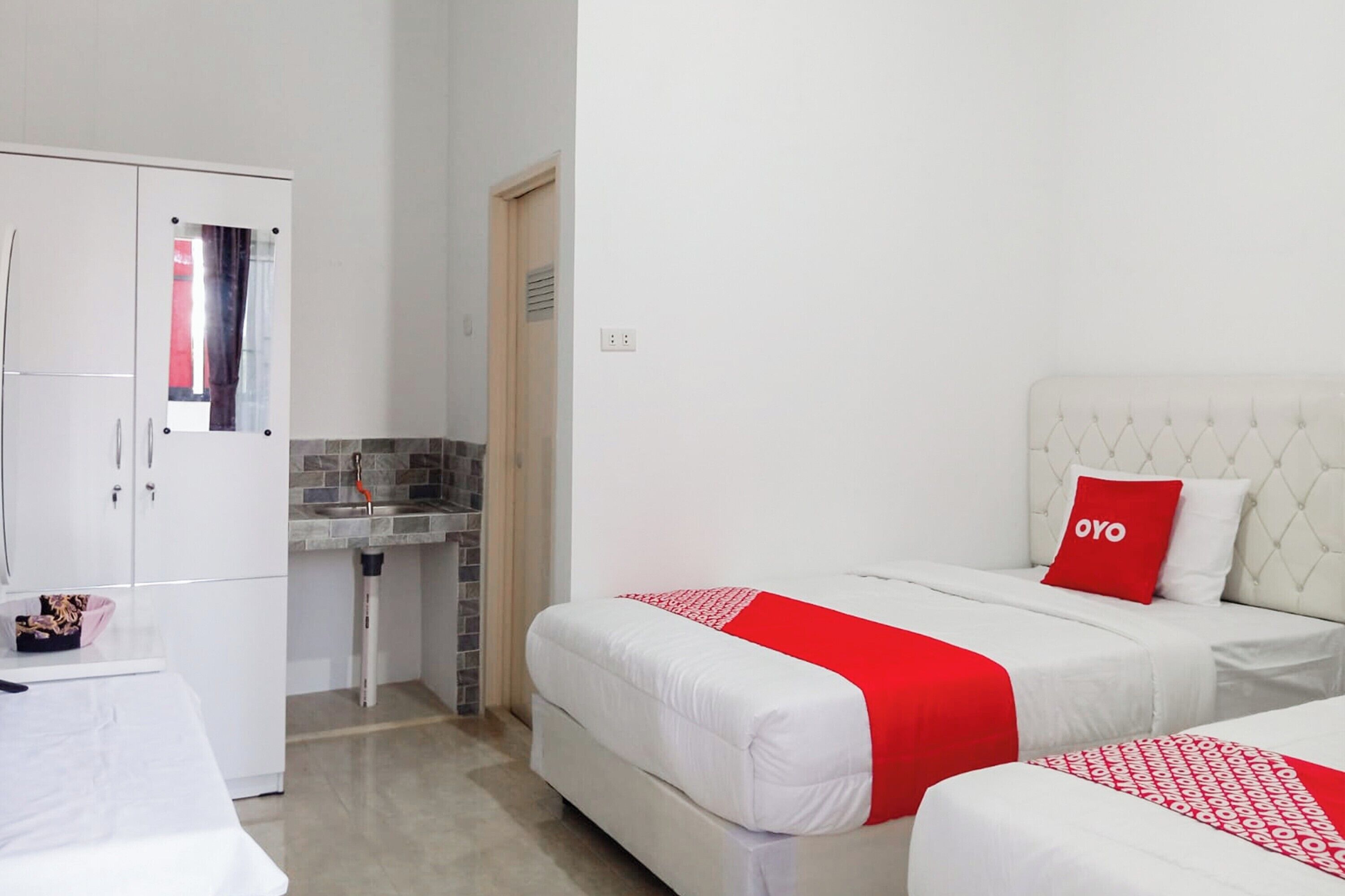 Habitación de hotel con dos camas, kitchenette y baño.