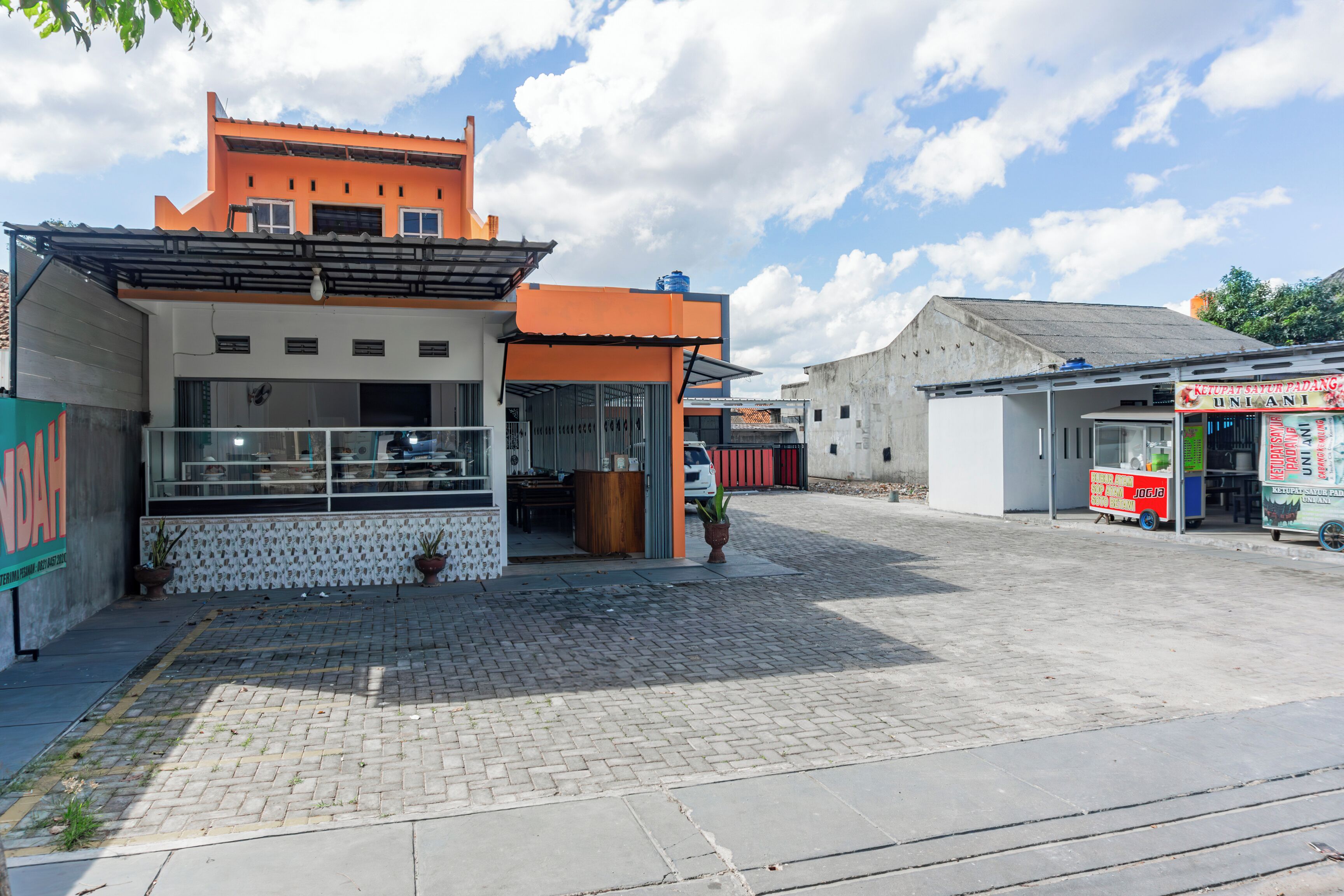 A commercial area with a building featuring a storefront and a sign that reads "UNLANI."