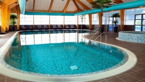 An indoor swimming pool with a tiled floor, wooden beams, and a tiled edge. - Veluwemeer Chalet Park Retreat (Hulshorst)