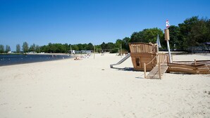 A beach with a wooden play structure and a lifeguard tower. - Veluwemeer Chalet Park Retreat (Hulshorst)