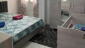 Quarto com cama, guarda-roupa, espelho e janela com cortinas.