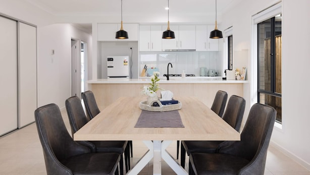 Una cocina moderna con armarios blancos, una isla central e iluminación colgante.