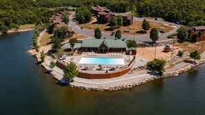 Un resort junto al lago con piscina, cabañas y una posada.