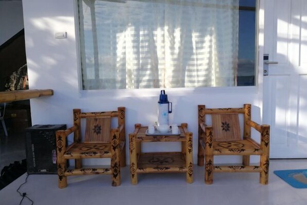 A room with two wooden chairs, a small table, and a window with curtains. - Jelly Sea Resort (Siquijor Island)