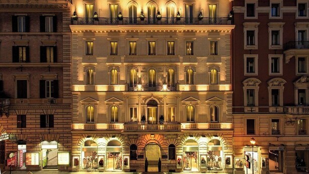 A multi-story building with a central entrance, balconies, and storefronts on the ground floor. - Spacious and Bright Apartment in the Heart of Rome (Roma)