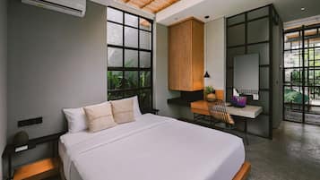 Un dormitorio moderno con una cama grande, un escritorio y una silla, con un ventanal y vistas a zonas verdes.