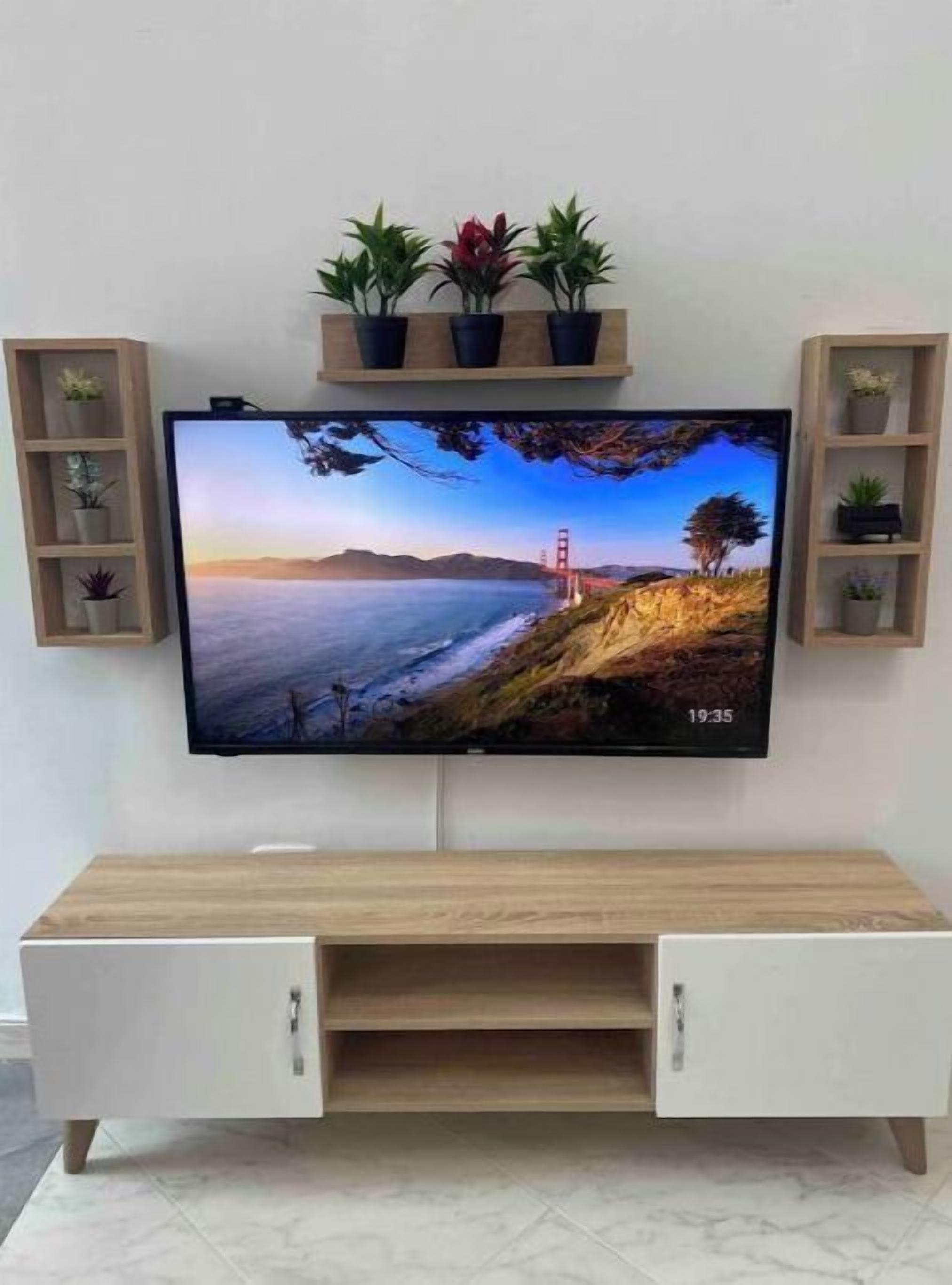 A flat-screen TV mounted on a wall above a wooden TV stand with cabinets.