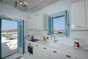 Villa | Cocina privada | Cafetera y tetera, refrigerador con congelador, microondas y horno 