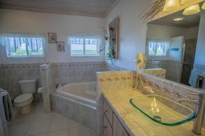 Un baño con bañera, inodoro y lavamanos.