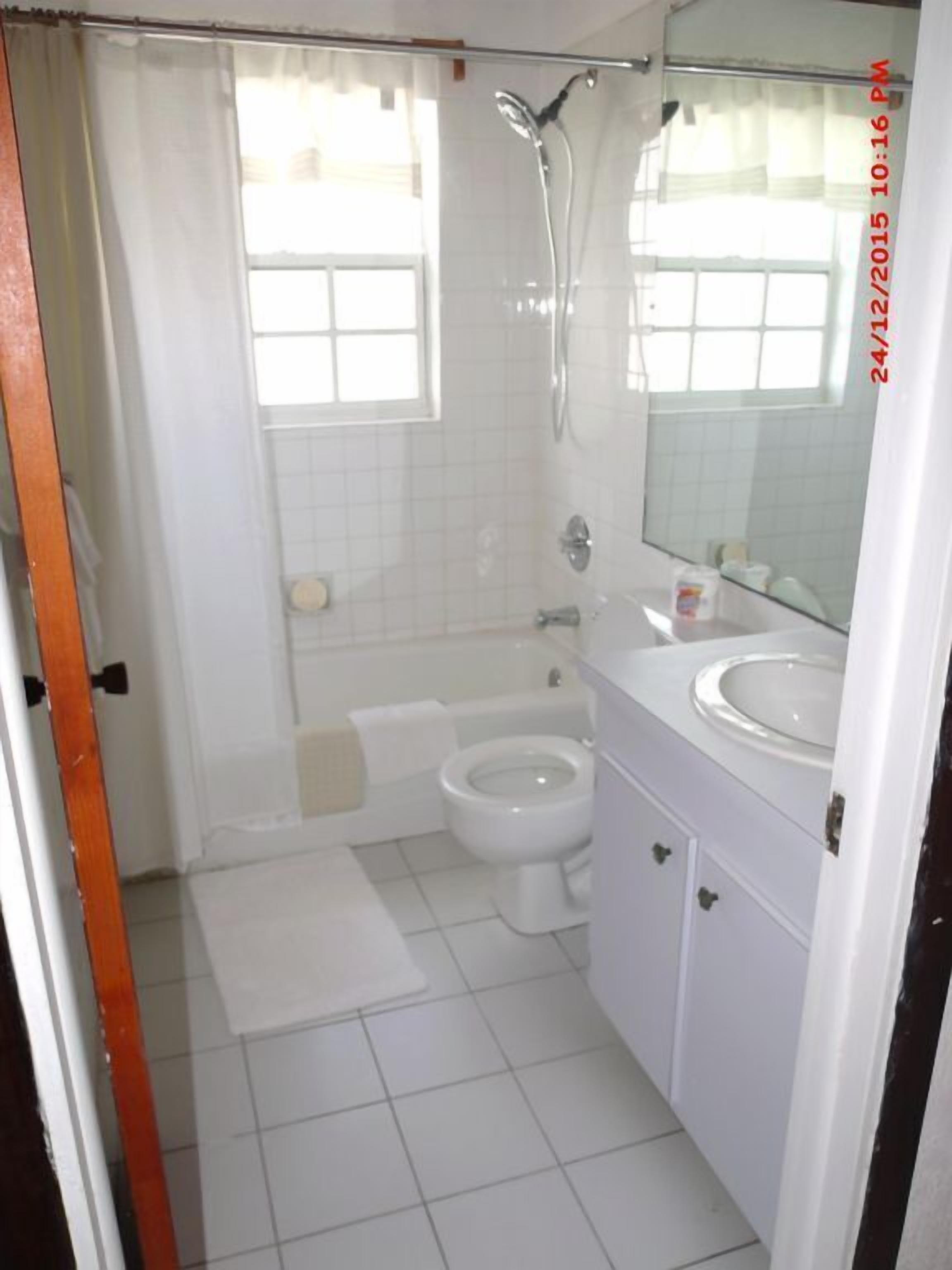 A bathroom with a bathtub, toilet, and sink.