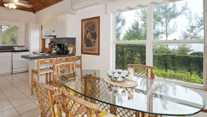 Una cocina moderna con armarios blancos, encimera negra y techo de madera.