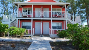 A two-story building with a red exterior and white trim, featuring balconies and a central entrance. - Windermere Wonder: Historic Home With Club Access (Savannah Sound)