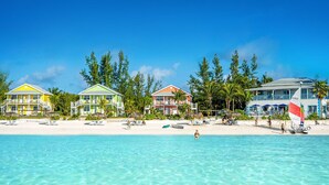 A beachfront hotel with multiple buildings, a sandy beach, and clear turquoise water. - Windermere Wonder: Historic Home With Club Access (Savannah Sound)