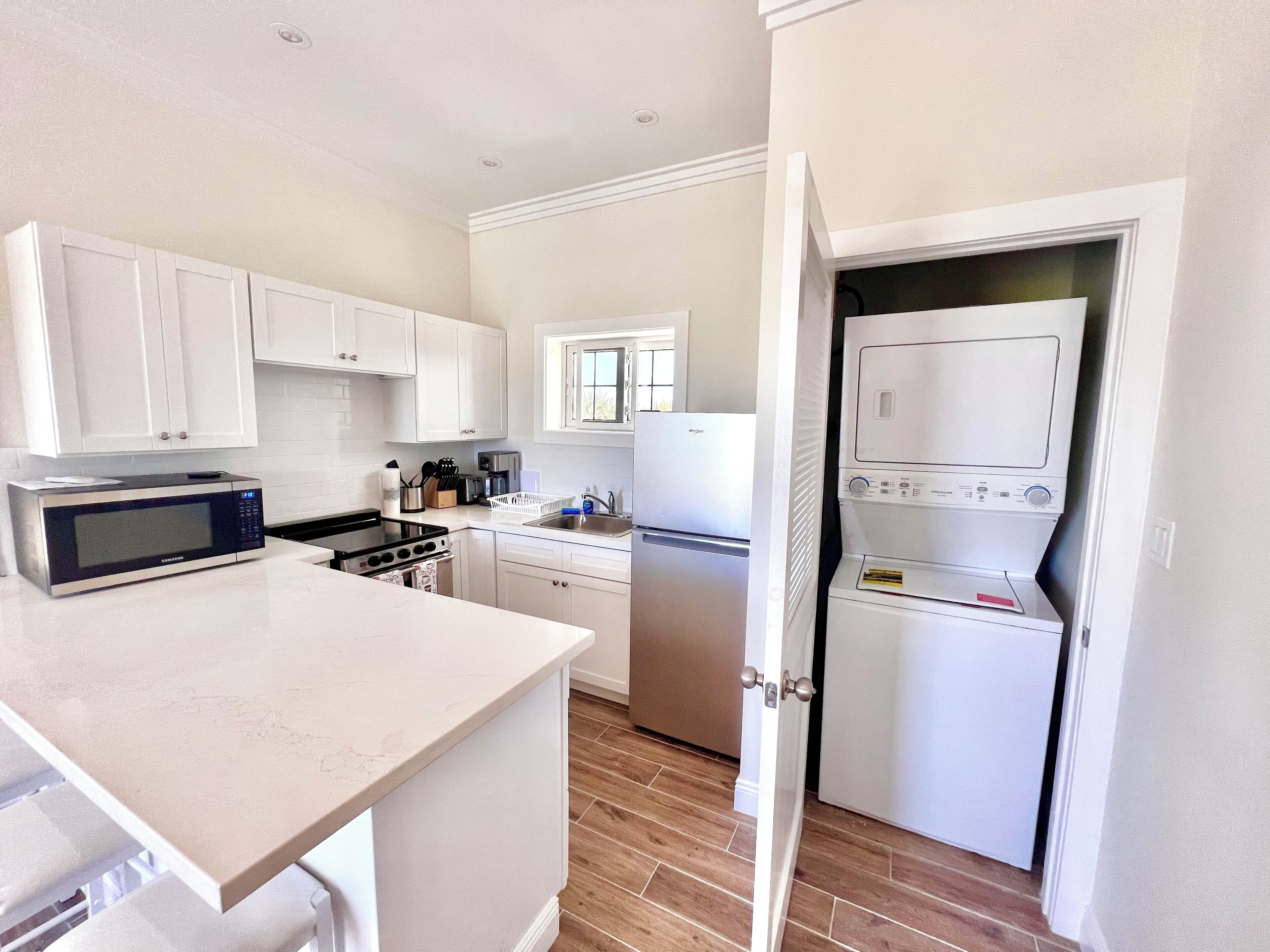 A modern kitchen with white cabinetry, a built-in microwave, stove, and dishwasher.