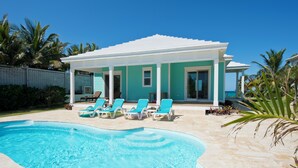 A pool area with a house in the background. - Buttonwood Bliss: Lux Condo With Views (James Cistern)