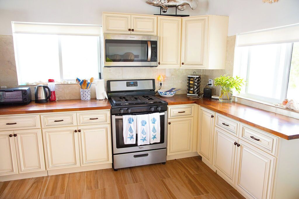 A kitchen with a stove, microwave, and cabinets.