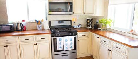A kitchen with a stove, microwave, and cabinets.