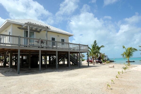 A beachfront property with a covered patio, a pool, and a view of the ocean.