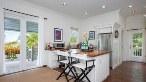 A spacious kitchen with a central island, white cabinetry, and a large refrigerator. - Seaside Escape: Private Beachfront Villa With Infinity Pool (Rock Sound)
