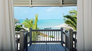A wooden deck with a view of a beach and ocean. - Seaside Escape: Private Beachfront Villa With Infinity Pool (Rock Sound)