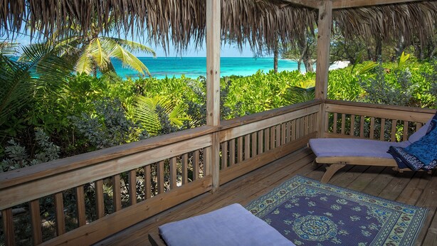 A wooden deck with a thatched roof overlooking a beach. - Oceanfront Oasis: Contemporary Villa With Pool (North Palmetto Point)