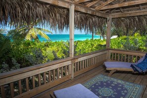 A wooden deck with a thatched roof overlooking a beach. - Oceanfront Oasis: Contemporary Villa With Pool (North Palmetto Point)