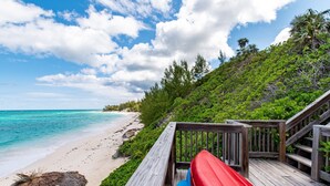 A wooden deck with a view of a beach and ocean. - Island Escape: Secluded Beachfront Cottage With Pool (North Palmetto Point)
