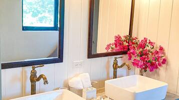 A bathroom with two sinks, a mirror, and a window.