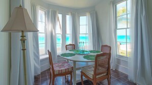 Een eethoek met een ronde tafel, stoelen en een lamp.