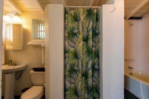 Egy fürdőszoba, amelyben WC, mosdókagyló és fürdőkád található.