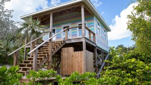 A colorful wooden house with a wooden staircase leading to a porch. - Historic Hideaway: Restored Waterfront Estate (Governor's Harbour)