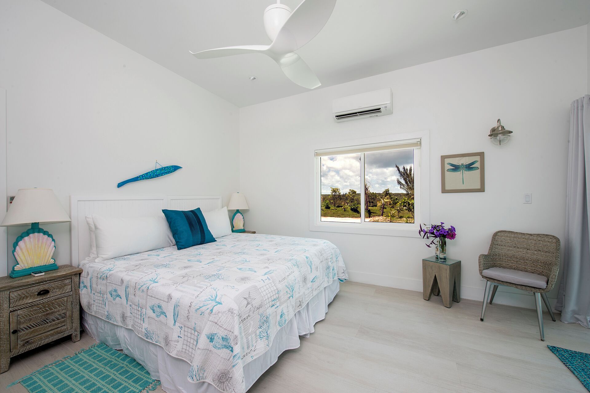 Una camera da letto con un letto, una finestra vista, una ventola a soffitto e un condizionatore d'aria a parete.