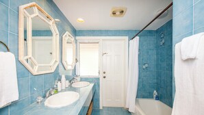 Un baño con dos lavamanos, una bañera y una ducha.