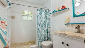 A bathroom with a shower, toilet, and sink. - Banks Road Beauty: Luxurious Beachfront Home (Governor's Harbour)