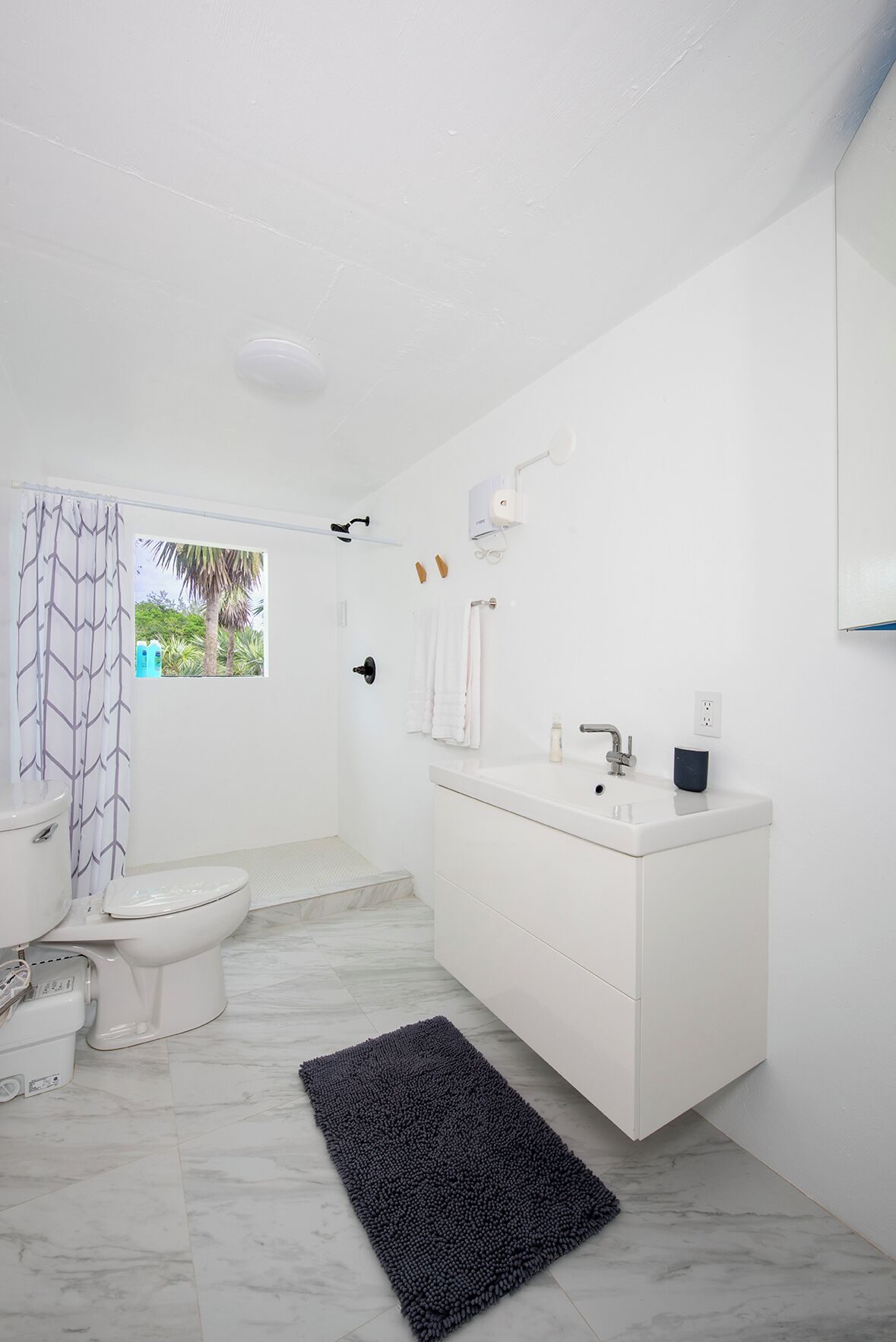 A modern bathroom with a toilet, sink, and shower area.