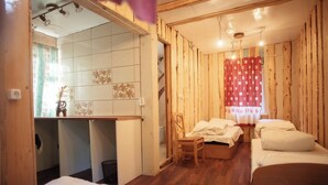 A room with two beds, a desk, and a chair.
