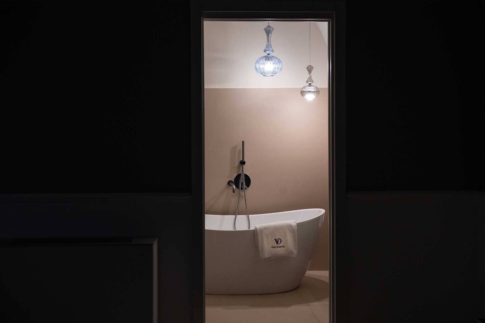 Un baño moderno con una bañera independiente, cabina de ducha de vidrio y una toalla colgada en la bañera.