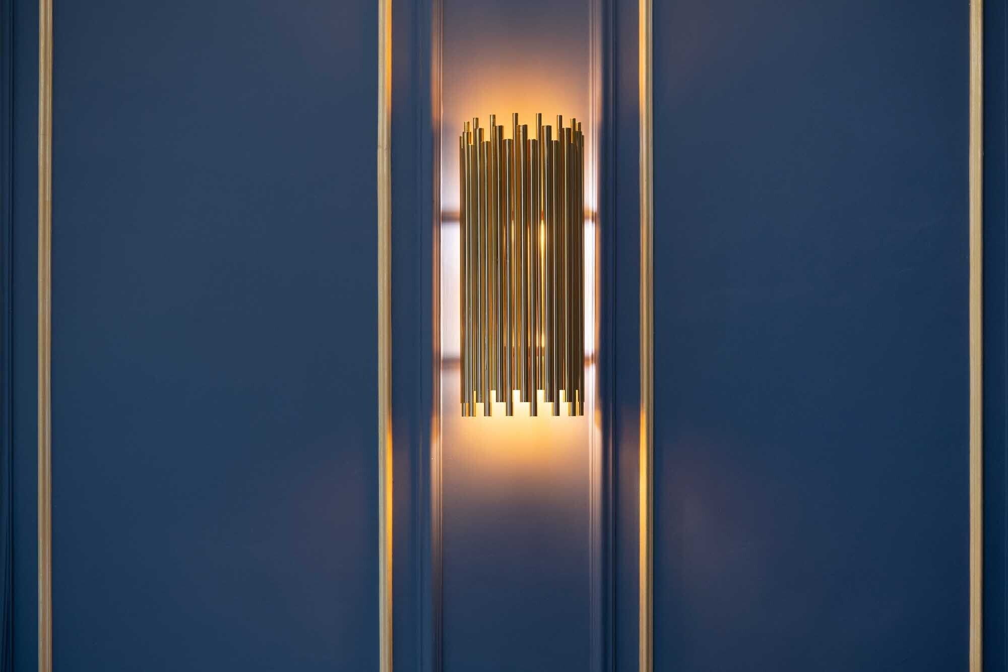 Un interior moderno con luminarias verticales y una pared azul.